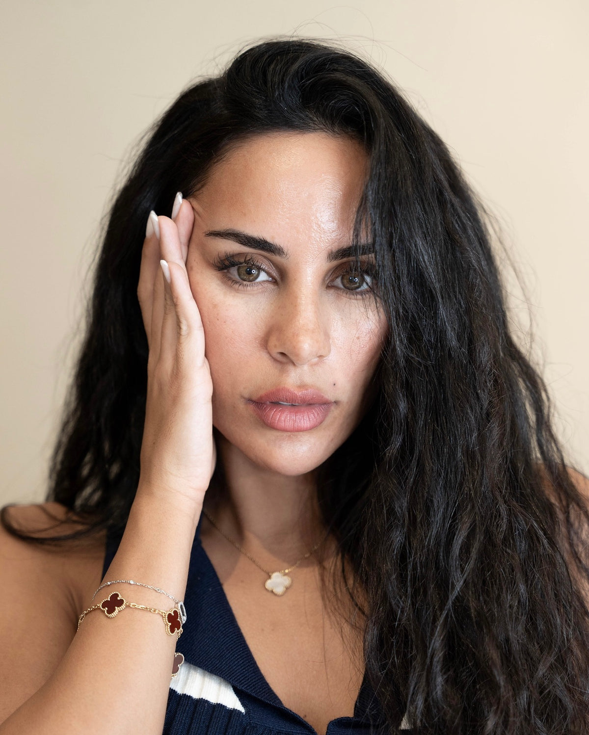 Woman with glowing, healthy skin gently touching her face with post-BBL treatment results