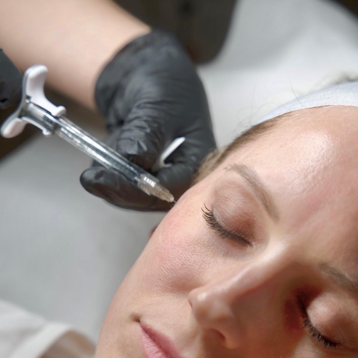 A client receiving Profhilo treatment while a specialist prepares the injection area under clinical lighting at BROWZ in Dubai.