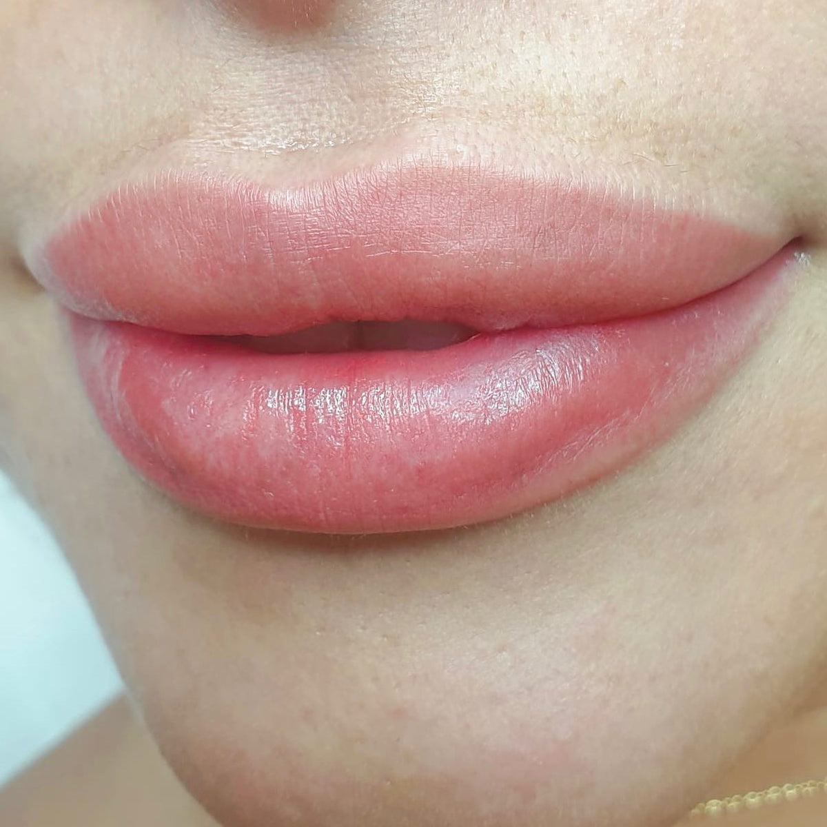 Lip blush on close up showing soft pigment diffusion, refined lip edges, even tone, hydrated texture, and a natural finish.
