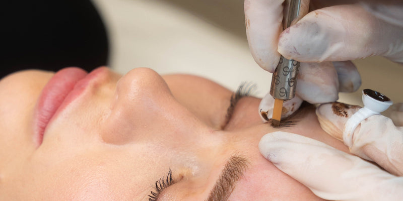 A woman receiving a semi-permanent makeup treatment in a professional clinic setting