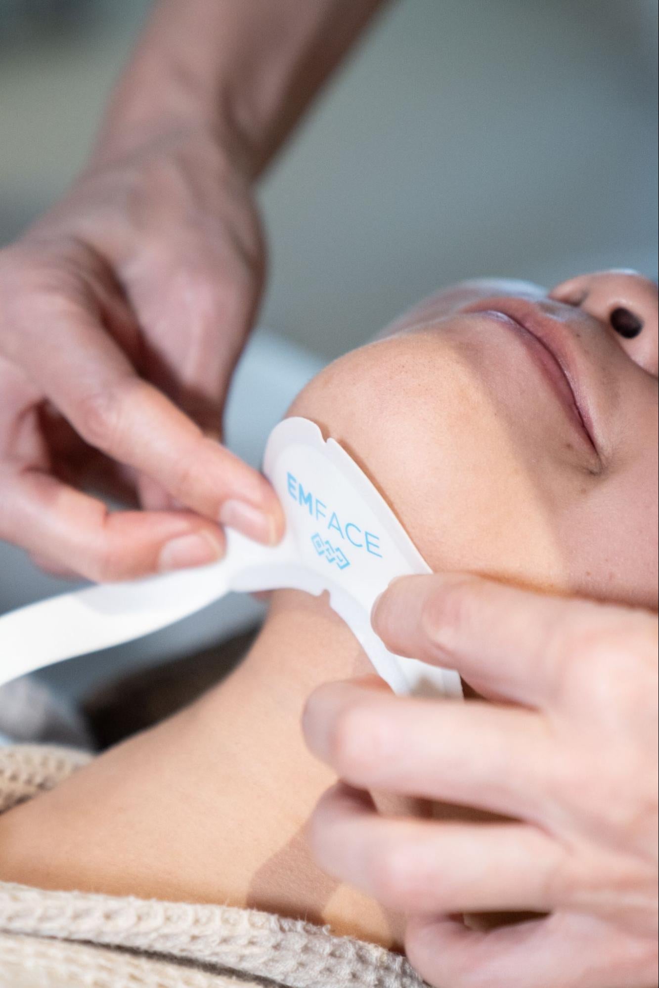 Woman undergoing EMFace treatment at BROWZ in Dubai, UAE to lift and tighten skin, reducing the appearance of a double chin