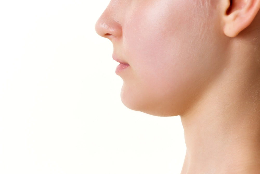 Woman showing double chin at BROWZ in Dubai, highlighting submental fullness and suitability for EMFace double chin treatment.