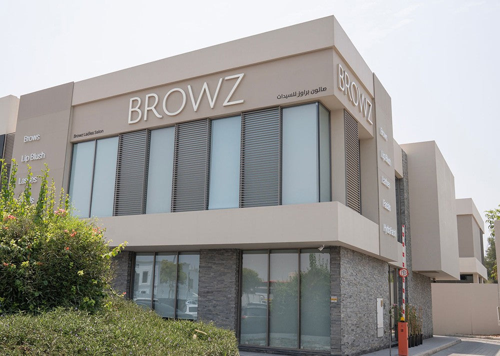 Modern two-story commercial building facade with large glass windows, horizontal louvered panels, and prominent BROWZ signage on the exterior.