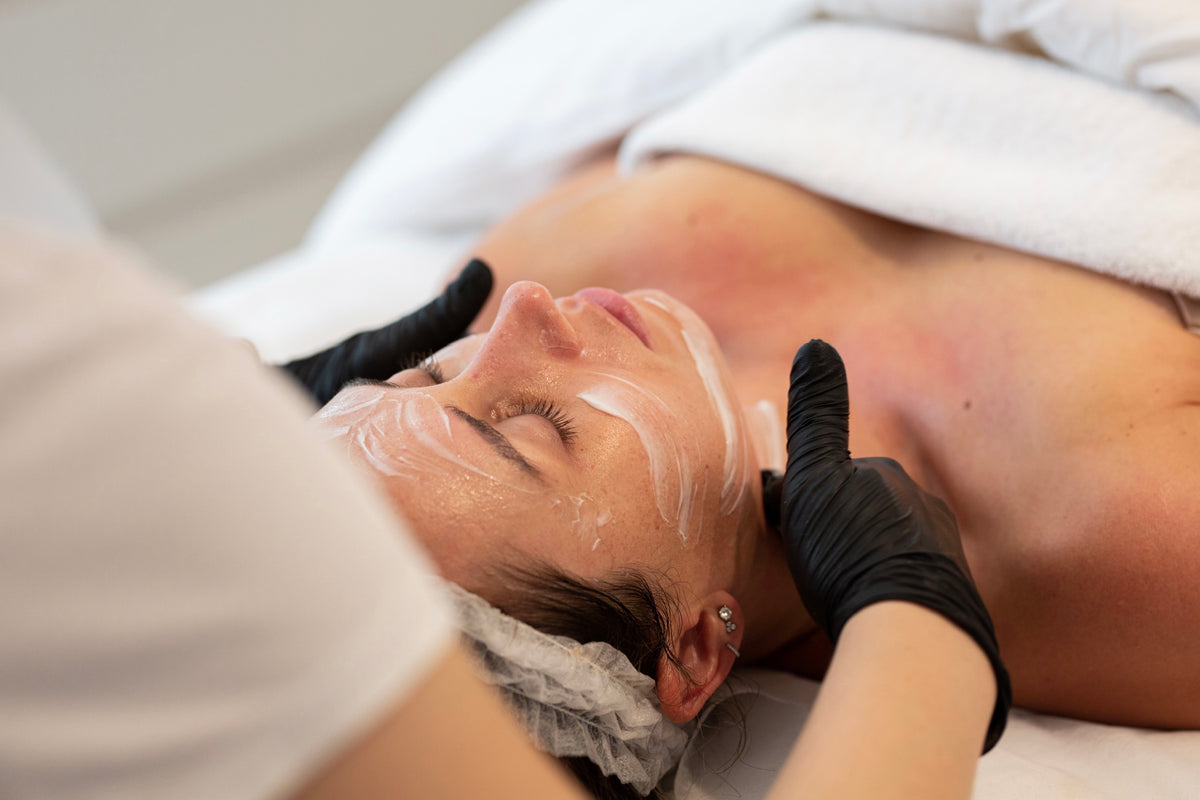Client receiving topical numbing cream on the face as preparation for Rejuran treatment.