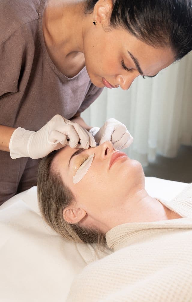 During a Korean Lash Lift, the therapist shows expertly done lashes, highlighting precise technique for a smooth-looking curl.
