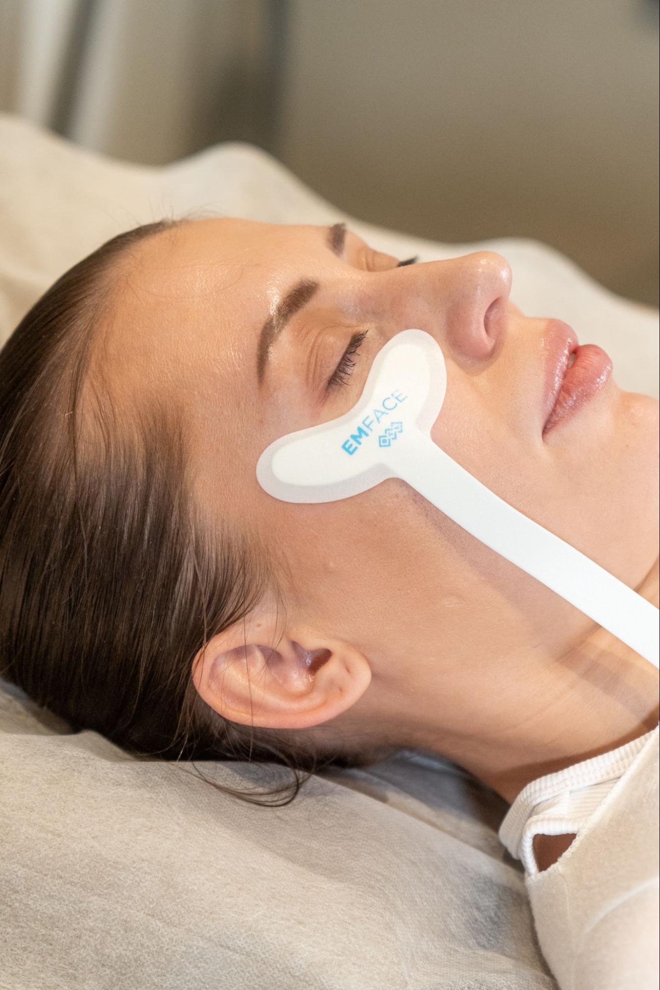 A woman undergoing EMFace treatment at BROWZ, Dubai, guided and administered by a specialist for glowing and lifted skin
