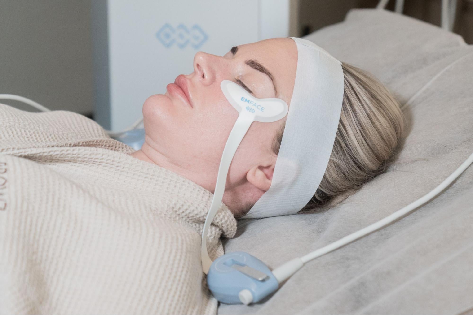 A woman with EMFace treatment patch to to boost collagen and elastin. To tone muscles and lift the skin naturally at BROWZ Dubai.